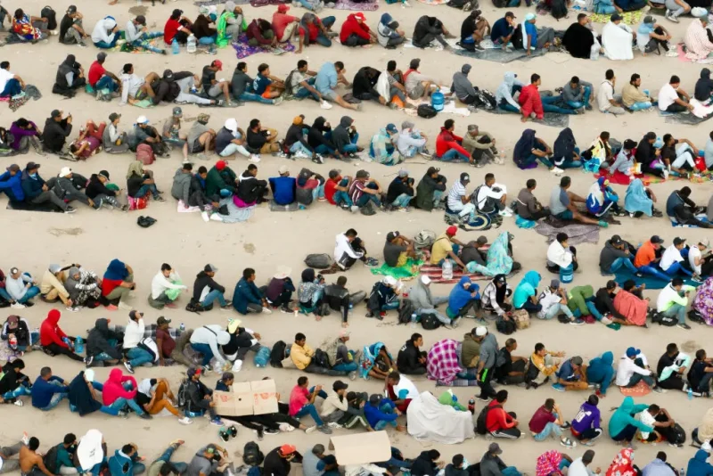 EL PASO, TEXAS - SEPTEMBER 21: In an aerial view, migrants are seen grouped together while waiting to be processed on the Ciudad Juarez side of the border on September 21, 2023 in El Paso, Texas. A recent surge of migrant crossings have occurred along the Southwestern region of the United States border. (Photo by Brandon Bell/Getty Images)