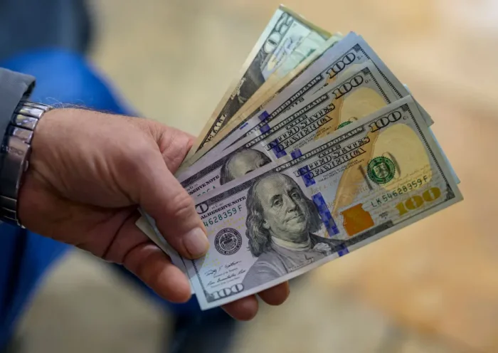 A teller shows US dollar bills at an exchange office at the Grand Bazaar in Istanbul on November 28, 2024. In recent weeks, the Turkish market has been increasingly unsettled by growing concerns over the circulation of counterfeit $50 and $100 bills. (Photo by Yasin AKGUL / AFP) (Photo by YASIN AKGUL/AFP via Getty Images)