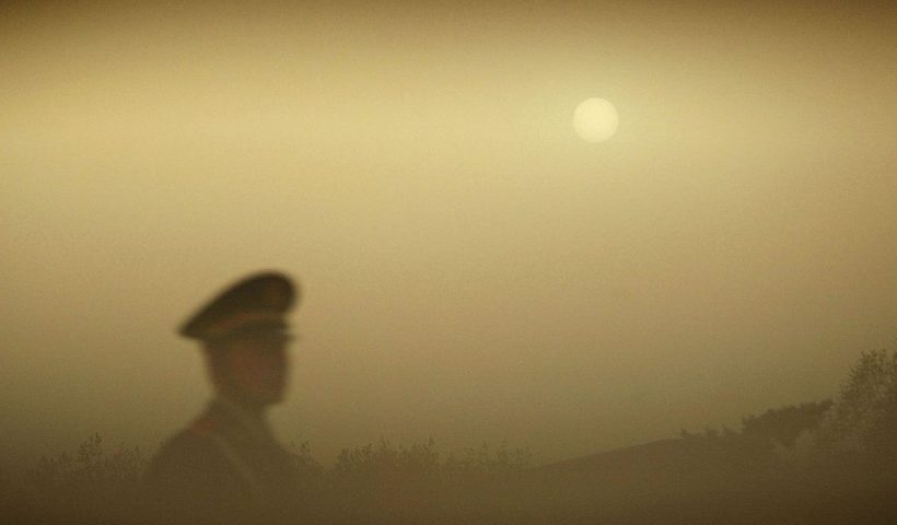 BEIJING, CHINA - APRIL 18: (CHINA OUT) A police officer patrols Tiananmen Square during a dust storm on April 18, 2006 in Beijing, China. A sandstorm hitting the China-Mongolia border on April 15 started to affect Beijing at midnight on April 16. The China Meteorological Administration (CMA) announced at a press conference that the sandstorm had dropped about 330,000 tons of dust on Beijing. According to forecasts, northern China will experience three sand storms between April 18 and 27.(Photo by China Photos/Getty Images)