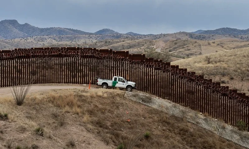 A Border Patrol officer sits inside his car as he guards the US/Mexico border fence, in Nogales, Arizona, on February 9, 2019. (Photo by Ariana Drehsler / AFP) (Photo by ARIANA DREHSLER/AFP via Getty Images)