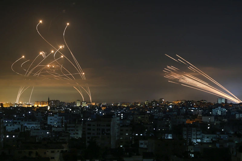 TOPSHOT - The Israeli Iron Dome missile defence system (L) intercepts rockets (R) fired by the Hamas movement towards southern Israel from Beit Lahia in the northern Gaza Strip as seen in the sky above the Gaza Strip overnight on May 14, 2021. - Israel bombarded Gaza with artillery and air strikes on Friday, May 14, in response to a new barrage of rocket fire from the Hamas-run enclave, but stopped short of a ground offensive in the conflict that has now claimed more than 100 Palestinian lives. As the violence intensified, Israel said it was carrying out an attack "in the Gaza Strip" although it later clarified there were no boots on the ground. (Photo by ANAS BABA / AFP) (Photo by ANAS BABA/AFP via Getty Images)