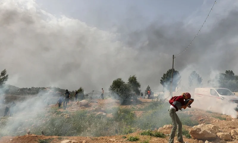 Palestinian protesters rush away from tear gas amid clashes with Israeli security forces during a protest in the village of Beita, south of Nablus in the occupied West Bank, on April 10, 2023, against a march by settlers to the nearby Israeli outpost of Eviatar. (Photo by Jaafar ASHTIYEH / AFP) (Photo by JAAFAR ASHTIYEH/AFP via Getty Images)