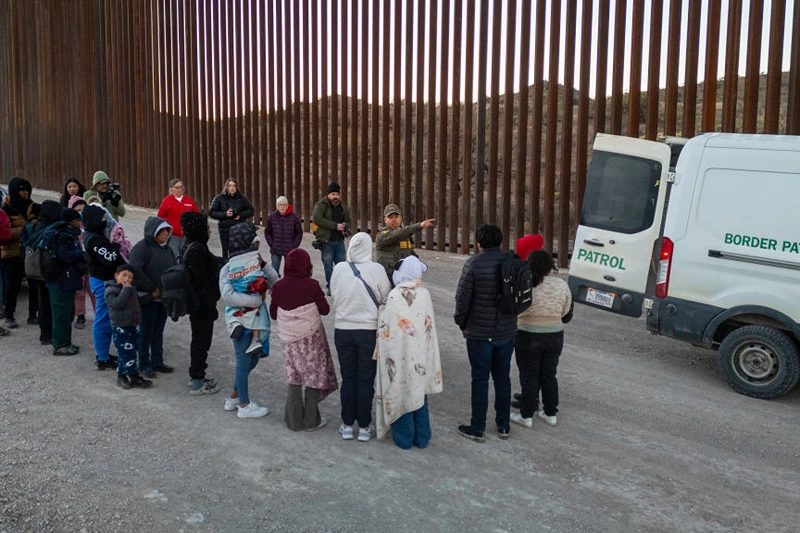 SASABE, ARIZONA - JANUARY 20: Immigrants wait to be transported by U.S. Border Patrol agents after crossing the U.S.-Mexico border on January 20, 2025 near Sasabe, Arizona. Immigrant families had passed through a gap in the Trump-built border wall hours before Donald J. Trump was inaugurated for a second time as President of the United States. (Photo by John Moore/Getty Images)