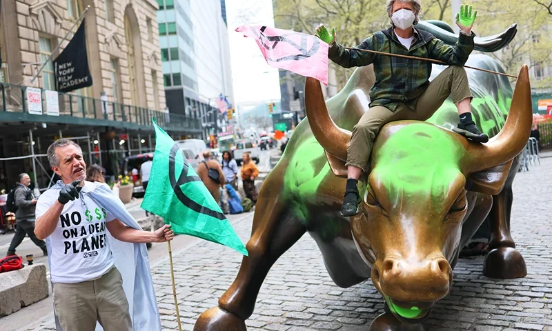 NEW YORK, NEW YORK - APRIL 22: Climate activist hold a protest at the Charging Bull statue in Bowling Green near the New York Stock Exchange on April 22, 2025 in New York City. Members of the climate activist group Extinction Rebellion vandalized the Charging Bull on Earth Day to protest what they say is Wall Street's complicitness in climate change. (Photo by Michael M. Santiago/Getty Images)