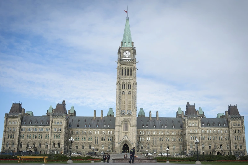 The Canadian Parliament is seen on October 23, 2014, in Ottawa, the day after multiple shootings in the capital city and Parliament buildings left a soldier dead and others wounded. A gunman whose name was on a terror watch list killed a soldier and attempted to storm Canada's parliament October 22 before the assembly's sergeant-at-arms shot him dead. The attack -- the second this week targeting Canadian military personnel -- came as Canadian jets were to join the US-led bombing campaign against Islamist militants in Iraq. AFP PHOTO/PETER MCCABE (Photo credit should read Peter McCabe/AFP via Getty Images)