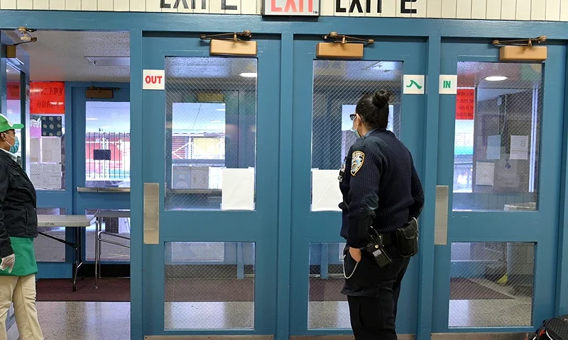 NEW YORK, NEW YORK - NOVEMBER 19: A "Feed Your Mind" to go meals distributor (L) and a school security guard wait for adults picking up meals and supplies on behalf of students on November 19, 2020 at Yung Wing School P.S. 124 in New York City. NYC Mayor Bill DeBlasio had to return the nation’s largest district had to all-remote teaching/learning as of today, with an indefinite outlook for reopening. (Photo by Michael Loccisano/Getty Images)