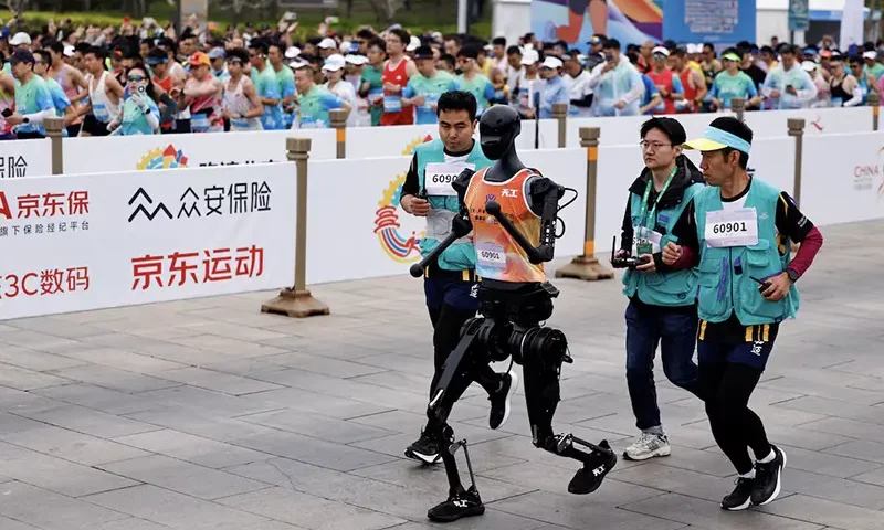 Humanoid robot "Tiangong" participates along with human runners in the E-Town Half Marathon & Humanoid Robot Half Marathon in Beijing, China April, 19 2025. REUTERS/Tingshu Wang